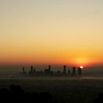 Sun rising above abstract purple horizon